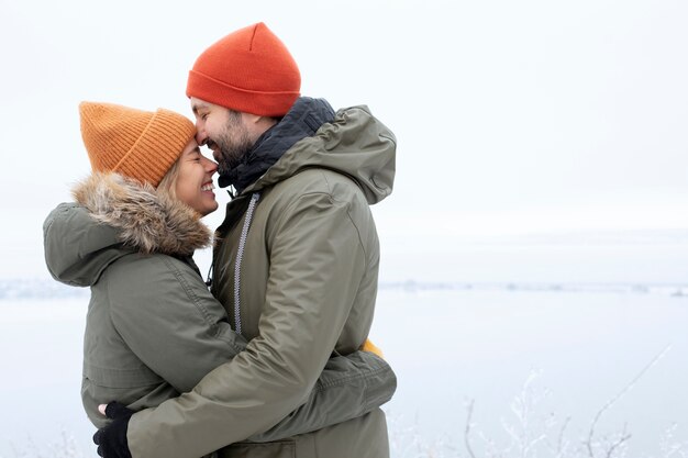 Tiempo de invierno de pareja sonriente de tiro medio