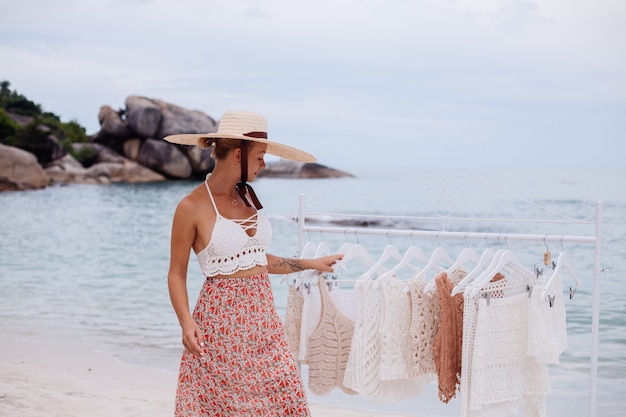 Tienda de playa al aire libre para ropa de punto mujer elección qué comprar del colgador de piso Concepto de ropa de punto de verano