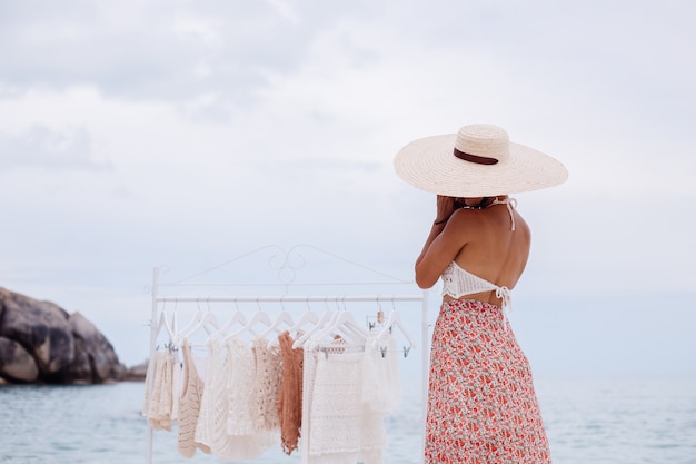 Tienda de playa al aire libre para ropa de punto mujer elección qué comprar del colgador de piso Concepto de ropa de punto de verano