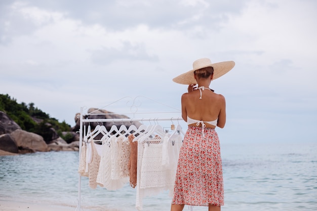 Tienda de playa al aire libre para ropa de punto mujer elección qué comprar del colgador de piso concepto de ropa de punto de verano