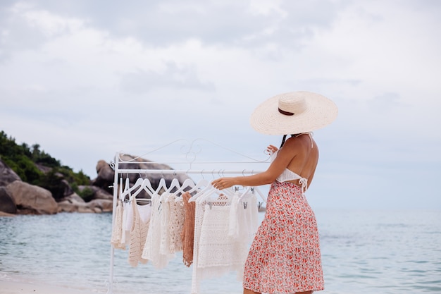 Tienda de playa al aire libre para ropa de punto mujer elección qué comprar del colgador de piso Concepto de ropa de punto de verano