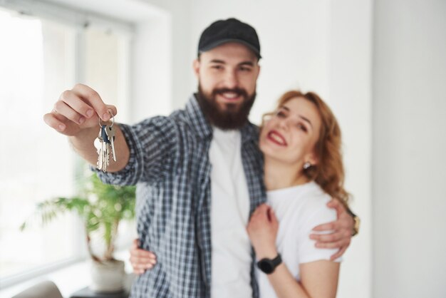 Tiene llaves. Pareja feliz juntos en su nueva casa. Concepción de mudanza