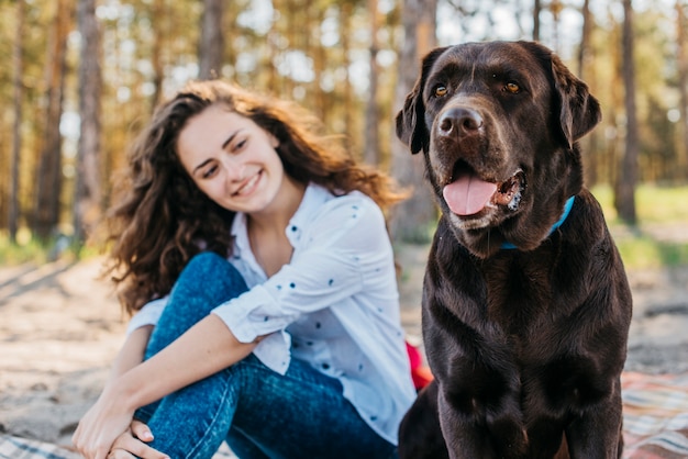 Tierna escena de chica feliz con su mascota en el bosque