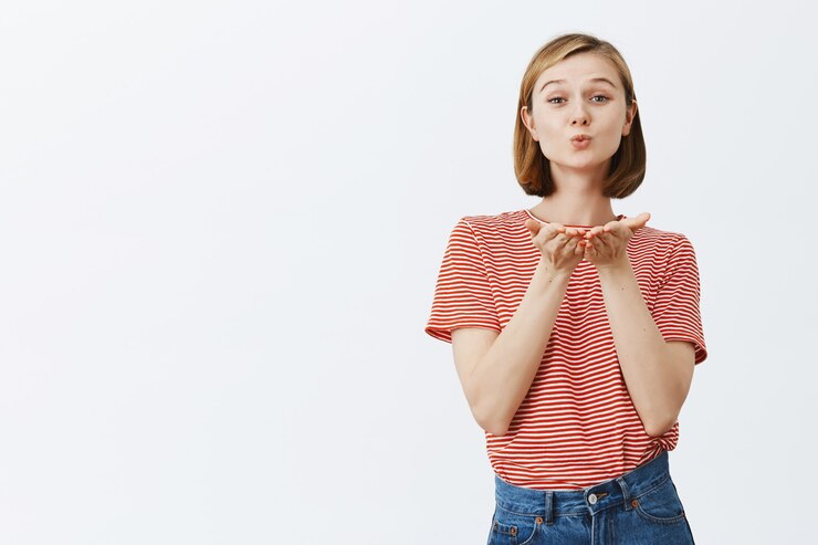 Foto gratuito tierna y femenina linda chica soplando aire beso
