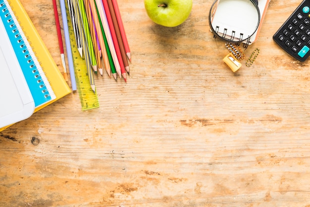 Útiles escolares coloridos sobre fondo de madera