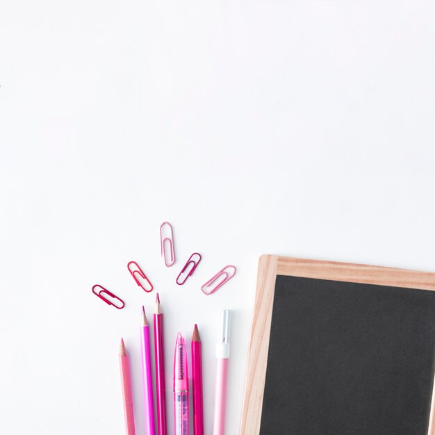 Útiles escolares con pizarra y lápices de color rosa
