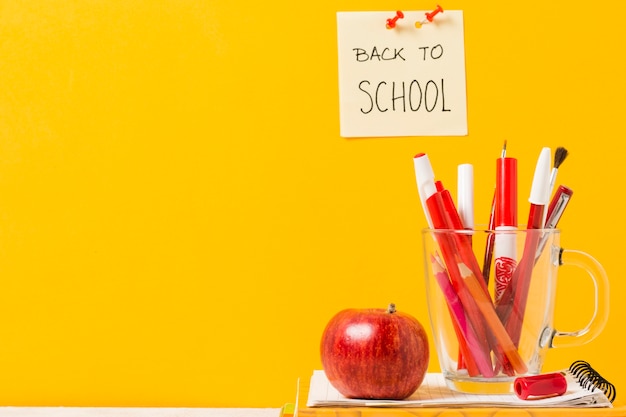 Útiles escolares sobre fondo naranja