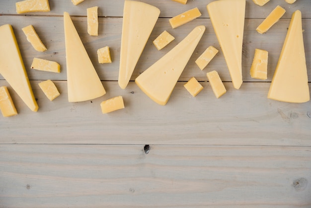 Tipo de queso cheddar en forma diferente en mesa de madera