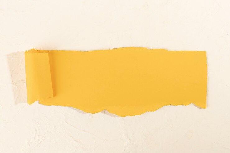 Foto gratuito una tira de papel amarillo torcido sobre un fondo de rosa pálido