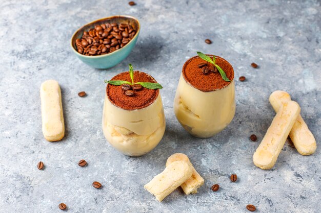 Tiramisú italiano tradicional en vidrios, visión superior del postre.