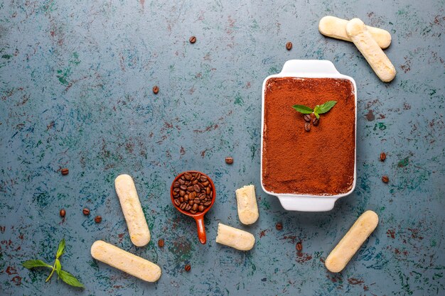 Tiramisú de postre italiano tradicional en placa de cerámica, vista superior.