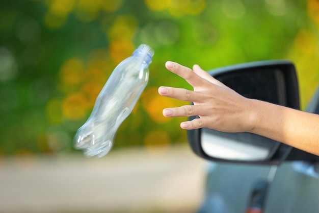 Tirar una botella de plástico desde la ventanilla del automóvil