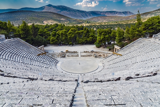 Foto gratuita tiro alto de un anfiteatro de piedra con árboles verdes y montañas en el fondo