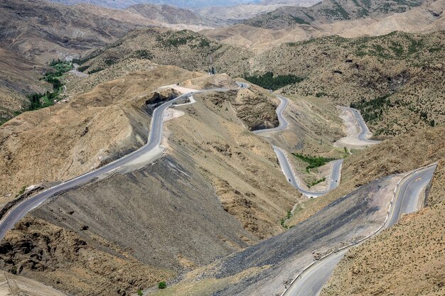 Tiro de alto ángulo de carreteras sinuosas en una zona con colinas vacías