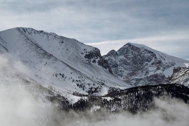 Tiro de alto ángulo de las montañas cubiertas de nieve bajo el cielo nublado