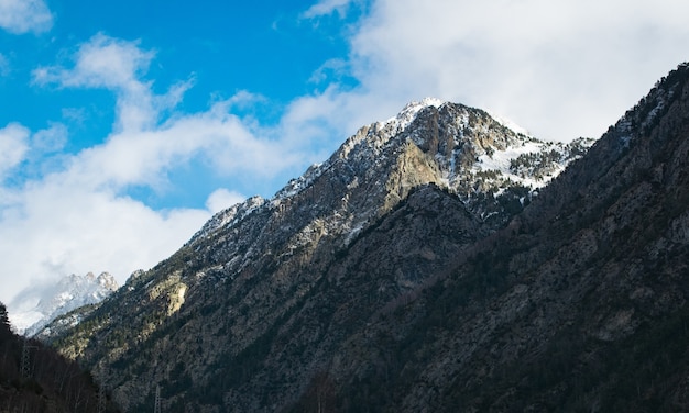 Tiro de ángulo bajo de altas montañas rocosas bajo un nublado