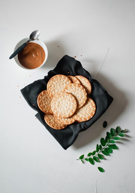 Tiro de ángulo alto de bocadillos y un tazón de caramelo sobre una superficie blanca