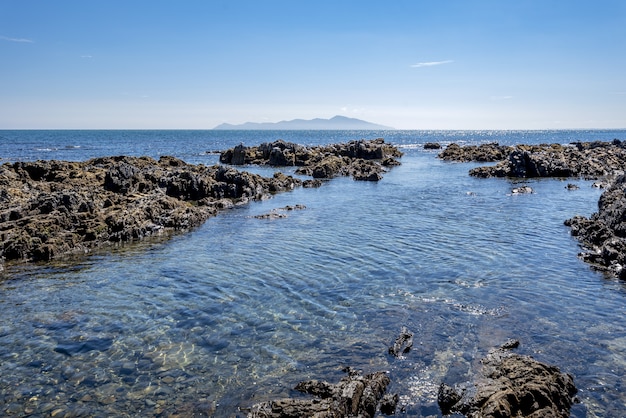 Tiro de ángulo alto de formaciones rocosas en el agua de la Bahía de Pukerua en Nueva Zelanda