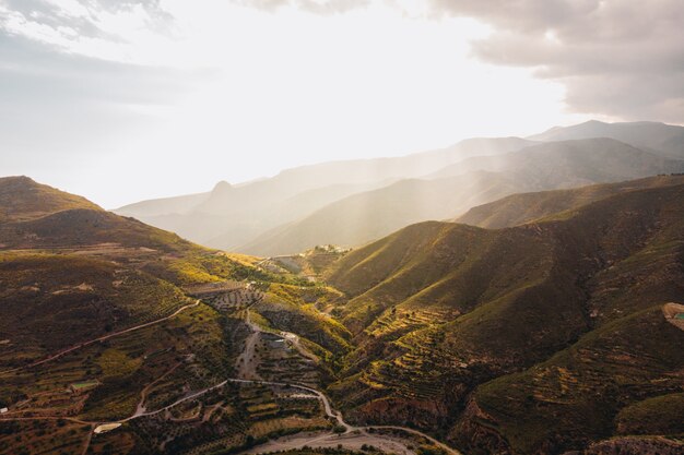 Tiro de ángulo alto de las hermosas montañas verdes bajo la luz del sol capturado en Andalucía, España.