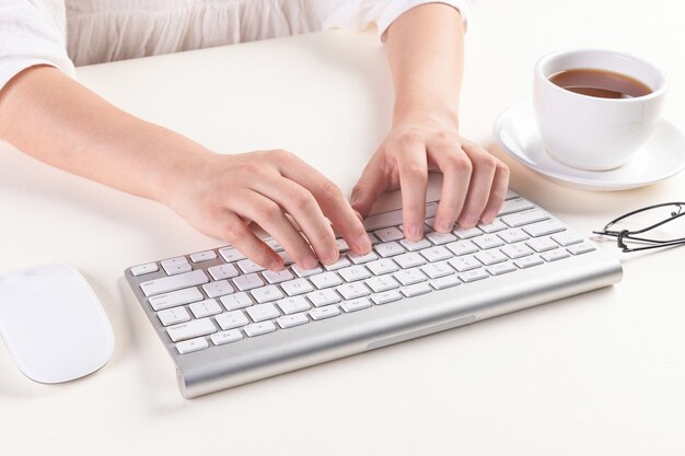 Tiro de ángulo alto de manos escribiendo en un teclado