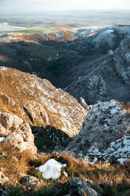 Tiro de ángulo alto de las montañas de alta colina cubiertas con poca nieve durante el día