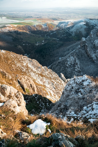 Tiro de ángulo alto de las montañas de alta colina cubiertas con poca nieve durante el día