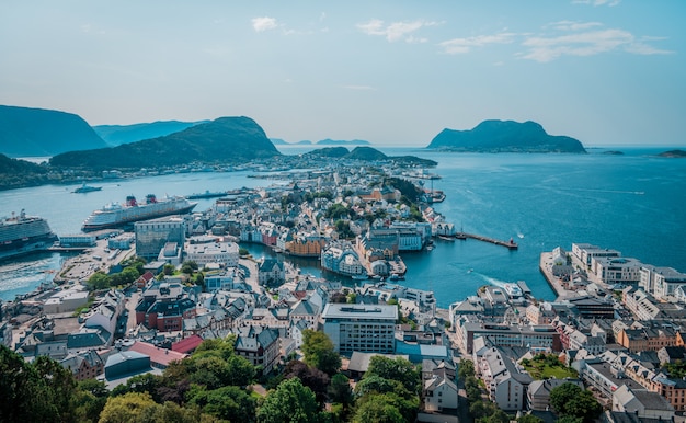 Tiro de ángulo alto de muchos edificios en la orilla del mar cerca de altas montañas en Noruega