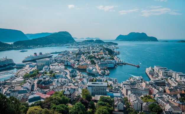 Tiro de ángulo alto de muchos edificios en la orilla del mar cerca de altas montañas en Noruega