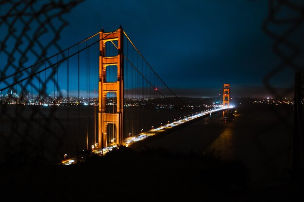 Tiro de ángulo alto del puente Golden Gate bajo un cielo azul oscuro por la noche