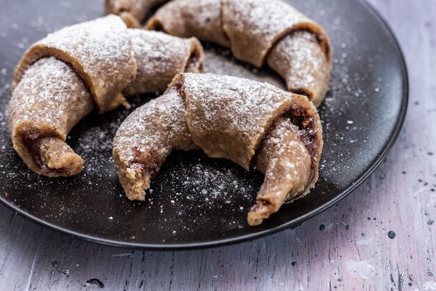 Foto gratuita tiro de ángulo alto de rollos veganos crudos en un plato oscuro colocado sobre una mesa de grunge púrpura