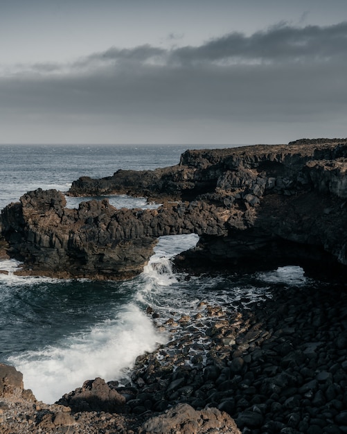 Tiro de ángulo alto vertical de la costa rocosa del mar en un día sombrío