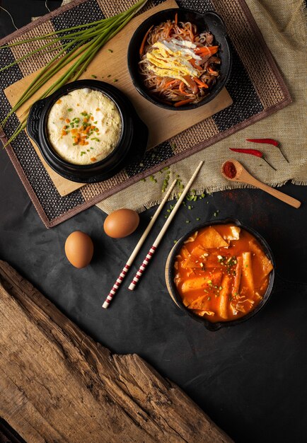 Tiro de ángulo alto vertical de tazones od hummus, verduras y sopa sobre una mesa negra