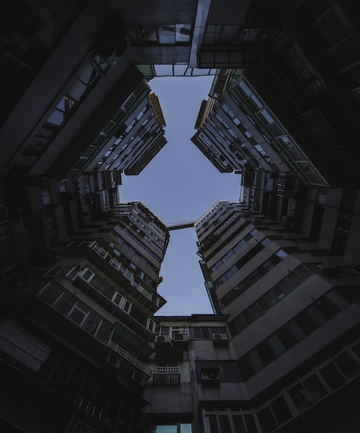 Tiro de ángulo bajo de altos edificios de apartamentos bajo el cielo oscuro