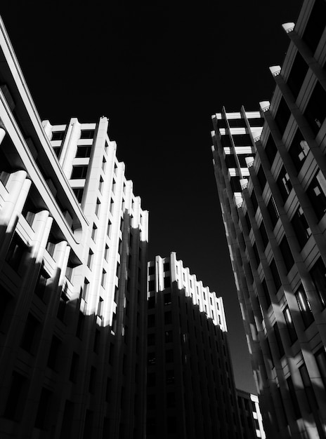 Tiro de ángulo bajo de altos edificios de piedra cerca uno del otro en blanco y negro