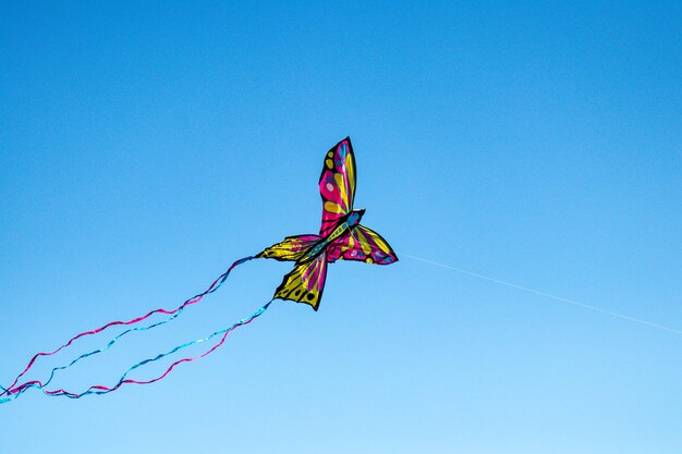 Tiro de ángulo bajo de una cometa colorida con forma de mariposa