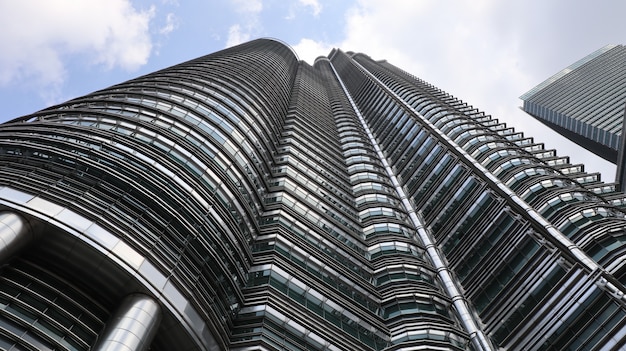 Foto gratuita tiro de ángulo bajo de un edificio alto de metal y vidrio en la mañana