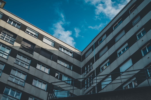 Tiro de ángulo bajo de un edificio marrón y blanco con ventanas bajo un cielo azul