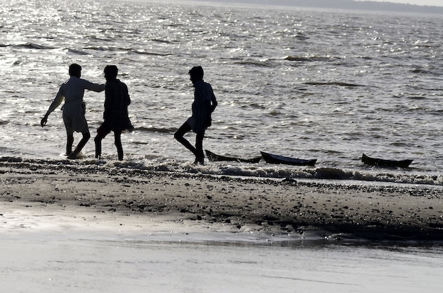 Tiro de ángulo bajo de gente caminando en la playa