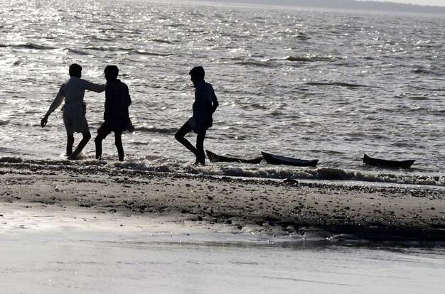 Tiro de ángulo bajo de gente caminando en la playa