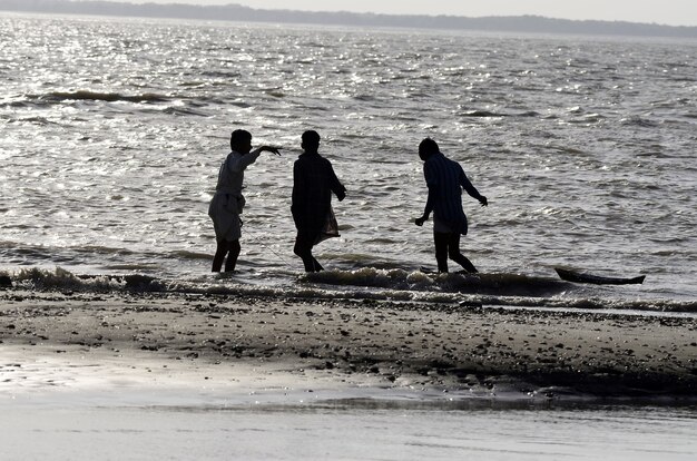 Tiro de ángulo bajo de gente caminando en la playa