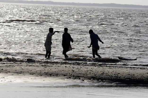 Tiro de ángulo bajo de gente caminando en la playa