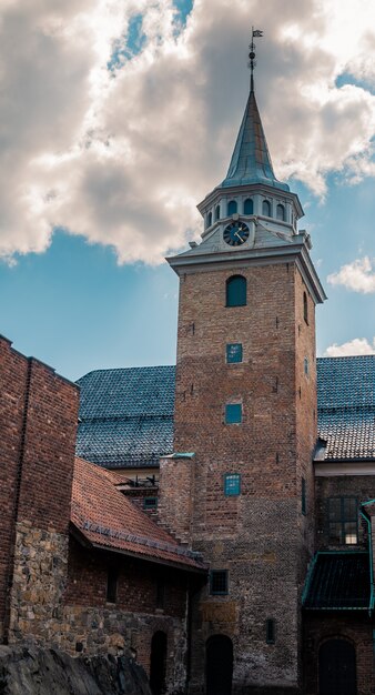 Tiro de ángulo bajo de la histórica fortaleza de Akershus bajo el hermoso cielo nublado en Oslo, Noruega