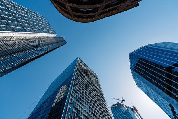 Tiro de ángulo bajo de los modernos edificios de cristal y rascacielos en un día claro