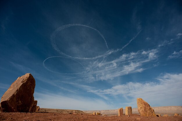 Tiro de ángulo bajo de rastros blancos en espiral en el cielo en el desierto