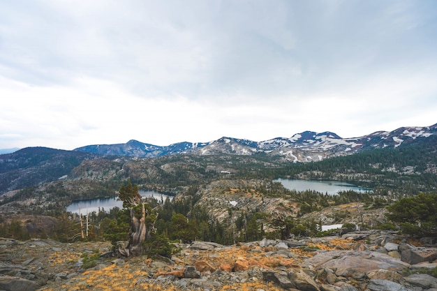 Tiro de Ariel de acantilados y montañas con árboles que crecen a su alrededor cerca del lago Tahoe, CA