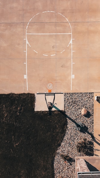 Tiro de arriba de un campo de baloncesto de cemento con el aro y las rocas