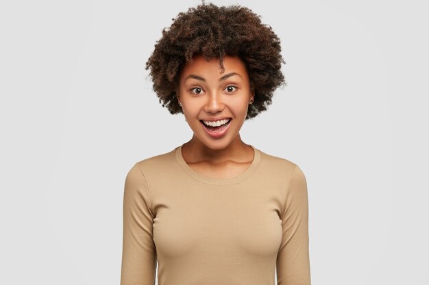 Tiro de cintura para arriba de feliz mujer Afro feliz se regocija el éxito en el trabajo