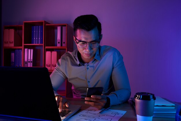 Tiro de la cintura del hombre trabajando hasta tarde en la computadora