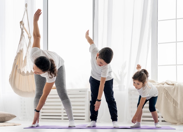 Tiro completo para adultos y niños haciendo deporte.