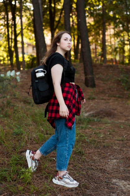 Tiro completo chica de cabello castaño en el bosque